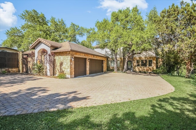 5711 Pool Canyon Cv, Austin, TX 78734 - view of front of home with stone siding, a garage, decorative driveway, a front yard, and a tile roof