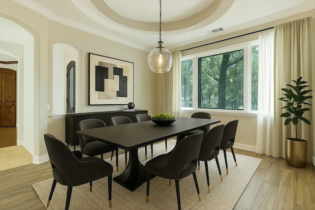 5711 Pool Canyon Cv, Austin, TX 78734 - dining room with a tray ceiling, arched walkways, light wood-type flooring, baseboards, and ornamental molding