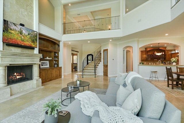 5711 Pool Canyon Cv, Austin, TX 78734 - living area with a high ceiling, a premium fireplace, ornamental molding, baseboards, and stairs