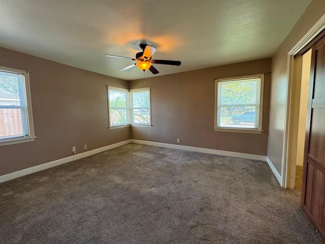 empty room with ceiling fan, baseboards, and carpet flooring