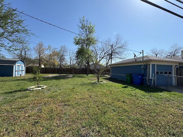 view of yard featuring an outdoor structure, a garage, a fenced backyard, and a storage shed