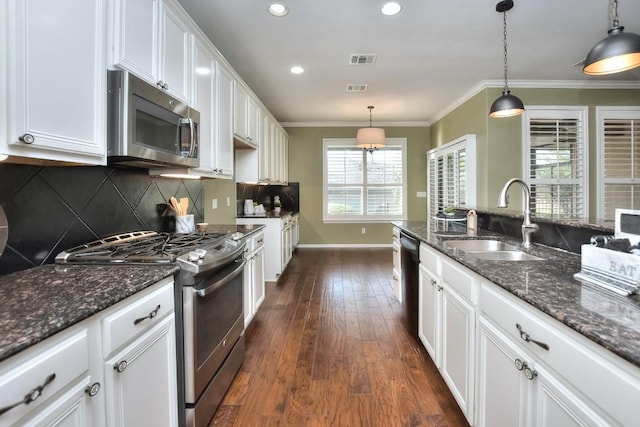 802 Apache Mountain Ln, Georgetown, TX 78633 - kitchen featuring appliances with stainless steel finishes, a sink, dark wood-type flooring, white cabinets, and decorative backsplash