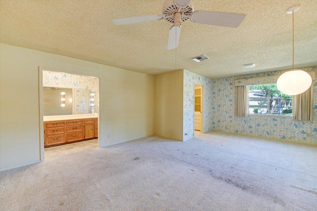 9401 Cedar Crest Dr, Austin, TX 78750 - empty room featuring carpet floors, a textured ceiling, wallpapered walls, and ceiling fan