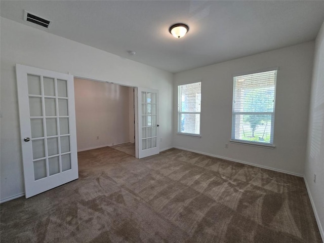 unfurnished bedroom with carpet, visible vents, baseboards, and french doors