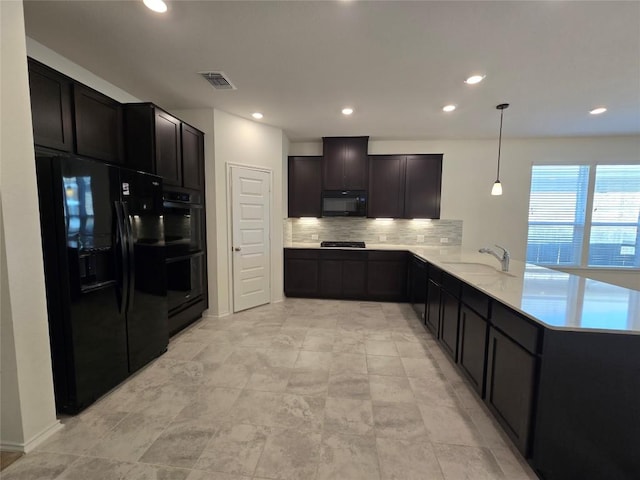 kitchen featuring a peninsula, a sink, tasteful backsplash, visible vents, and black appliances