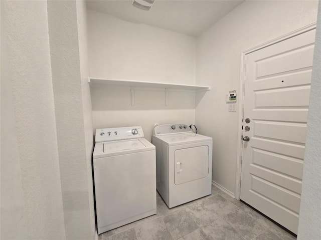 laundry area featuring washer and clothes dryer, light tile patterned floors, and laundry area