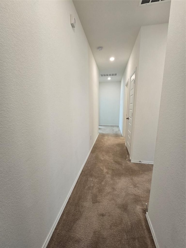 corridor featuring recessed lighting, carpet floors, visible vents, and baseboards