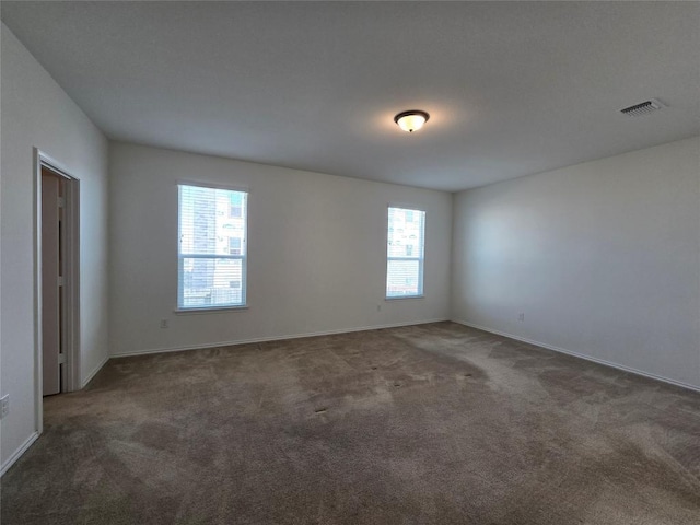 spare room with visible vents, baseboards, and carpet flooring