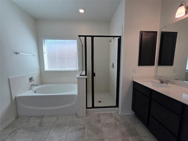 bathroom with a bath, vanity, and a stall shower