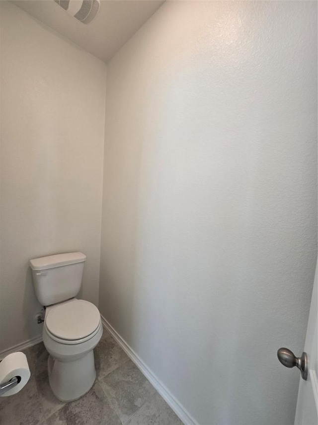 bathroom with toilet, baseboards, and tile patterned floors