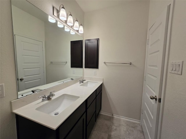 bathroom with baseboards, a sink, and double vanity