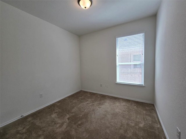 unfurnished room featuring plenty of natural light, carpet floors, and baseboards