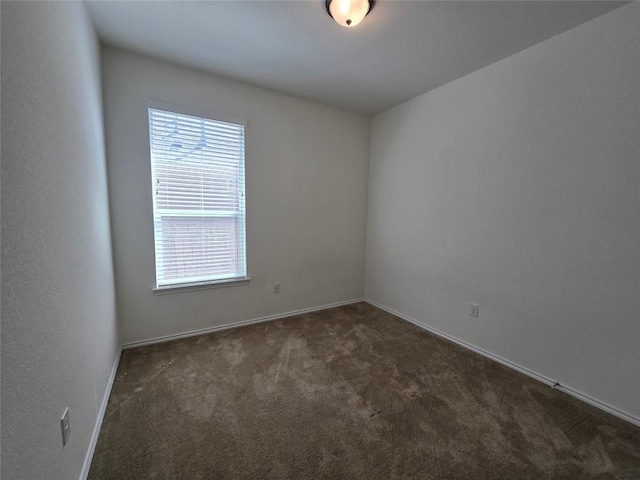 carpeted empty room featuring a wealth of natural light and baseboards