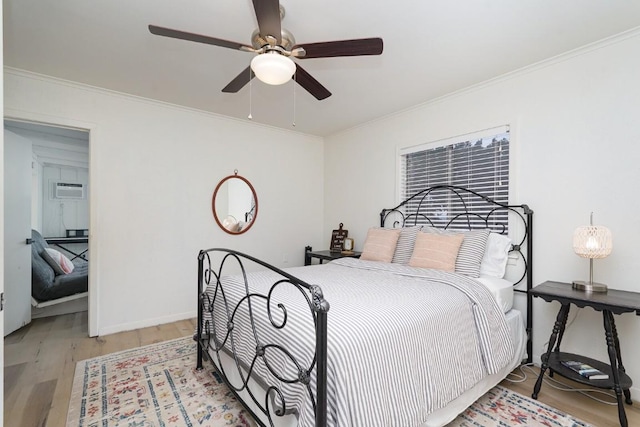 bedroom with light wood finished floors, crown molding, and ceiling fan