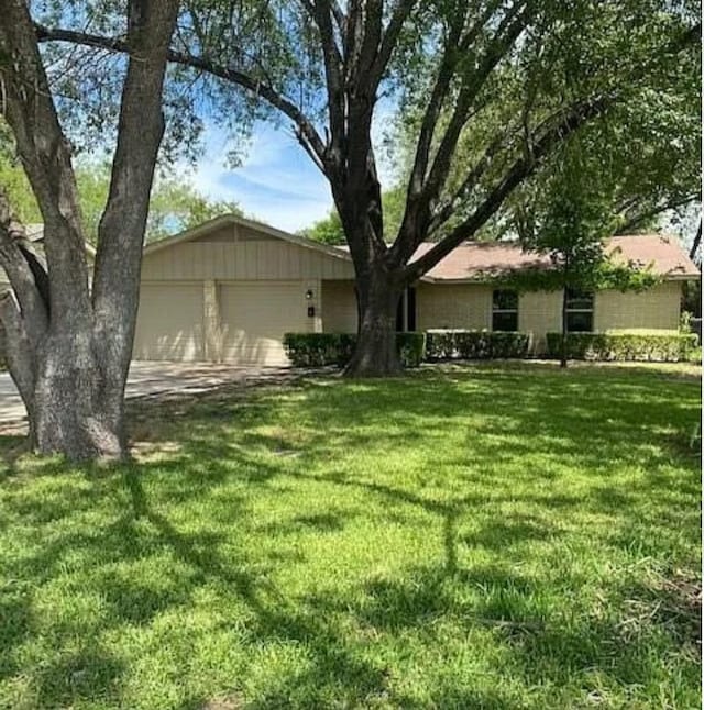 view of front of house featuring concrete driveway, an attached garage, and a front yard