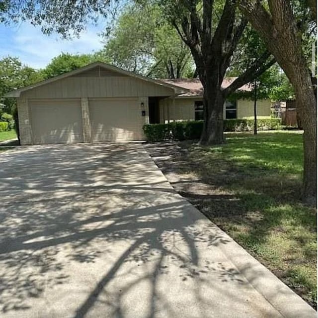 single story home with a garage, driveway, and a front lawn