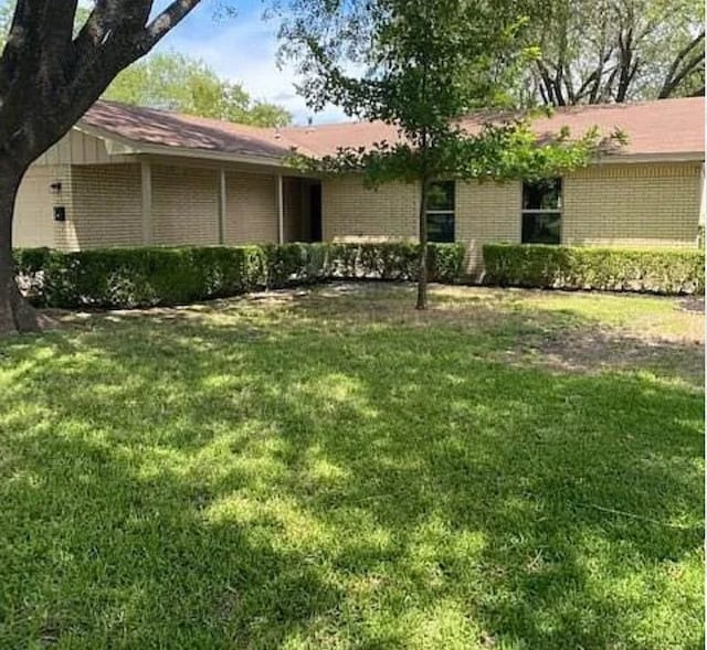 view of front of home featuring a front lawn and brick siding