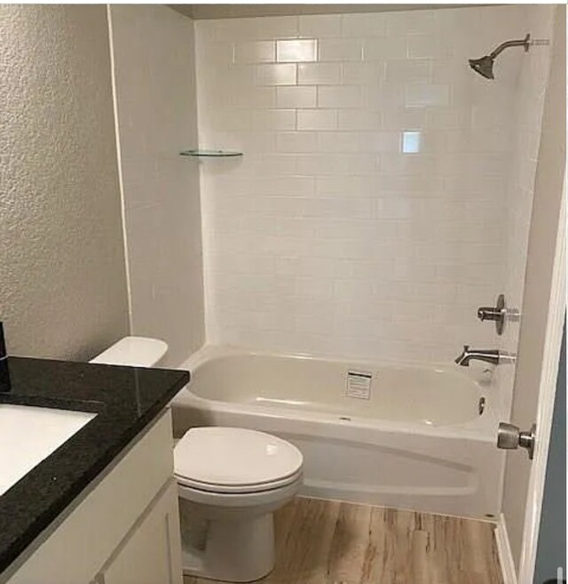 bathroom with tub / shower combination, wood finished floors, toilet, and vanity