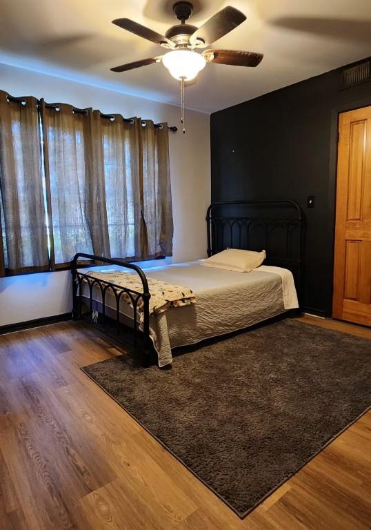 bedroom with a ceiling fan and wood finished floors