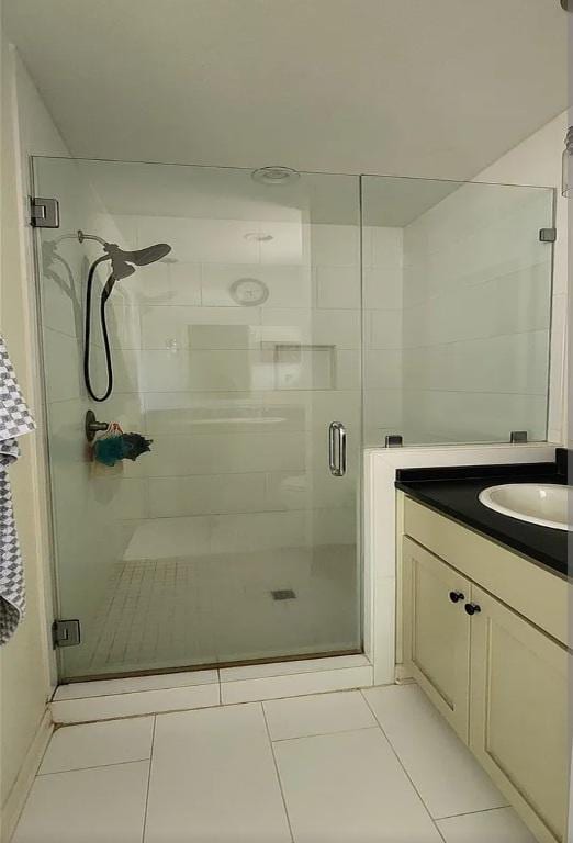 full bath featuring a shower stall, vanity, and tile patterned floors