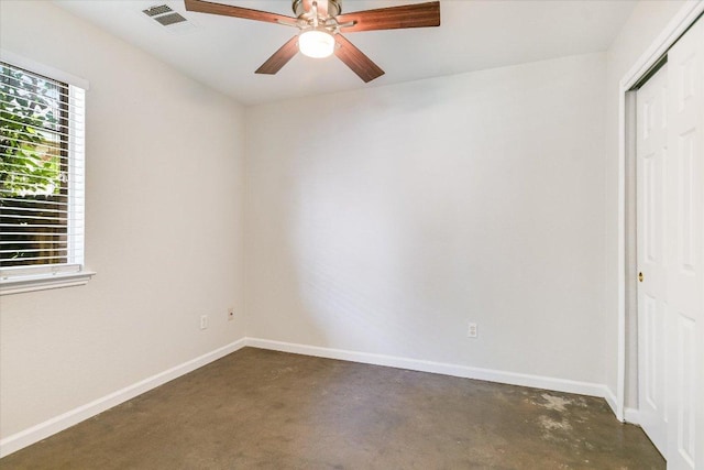 empty room with ceiling fan, baseboards, visible vents, and concrete floors