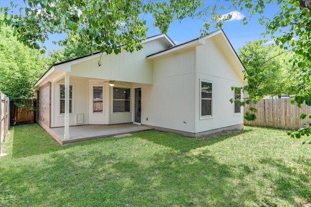 back of property featuring a fenced backyard, a ceiling fan, a yard, and a patio