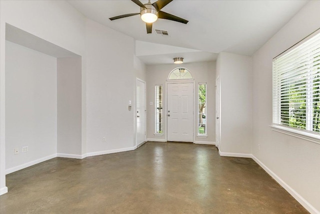 foyer entrance with baseboards, visible vents, finished concrete floors, lofted ceiling, and a ceiling fan