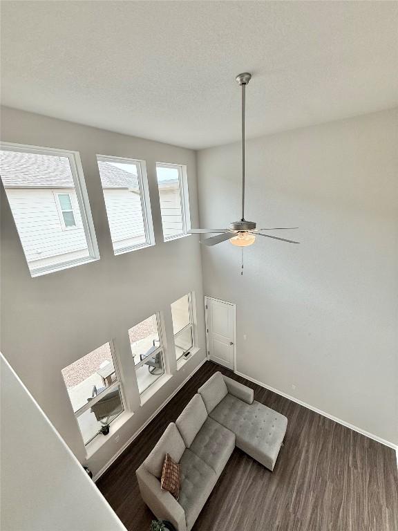 793 Lone Peak Way, Dripping Springs, TX 78620 - unfurnished living room featuring wood finished floors, a ceiling fan, and a textured ceiling
