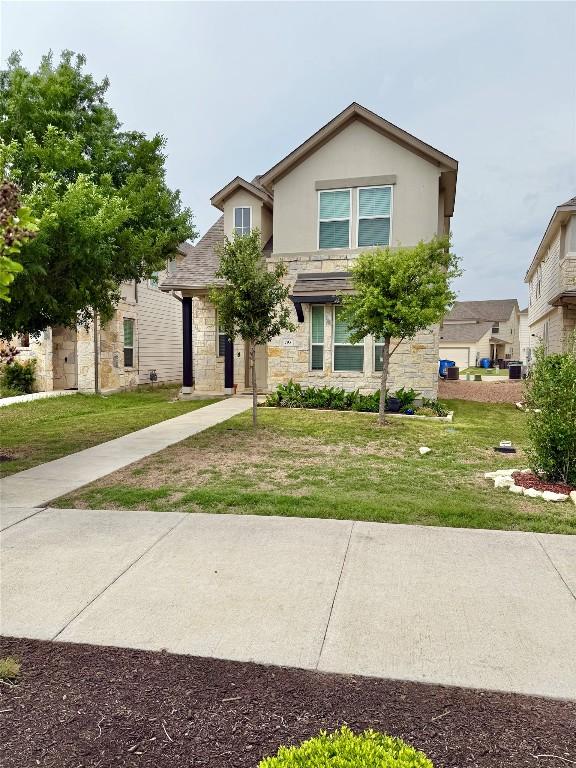 793 Lone Peak Way, Dripping Springs, TX 78620 - traditional-style home with stone siding, a front yard, and stucco siding