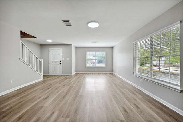 8139 Evadean Cir, Austin, TX 78745 - unfurnished living room with stairway, wood finished floors, and baseboards