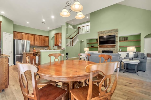 3820 Lagoona Dr, Round Rock, TX 78681 - dining area with a fireplace, light wood-style flooring, stairway, recessed lighting, and baseboards