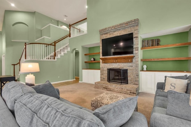 3820 Lagoona Dr, Round Rock, TX 78681 - carpeted living room featuring stairway, a high ceiling, a fireplace with raised hearth, baseboards, and built in features