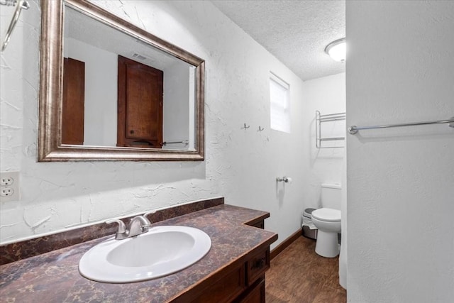 502 Grace Ln, Austin, TX 78746 - bathroom with a textured ceiling, vanity, toilet, and a textured wall