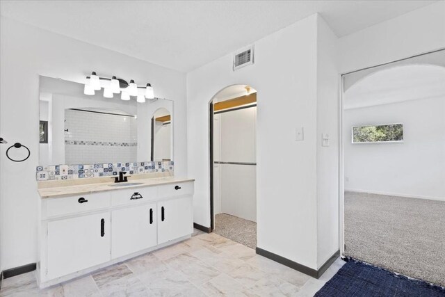 502 Grace Ln, Austin, TX 78746 - full bath featuring vanity, a tile shower, baseboards, and decorative backsplash