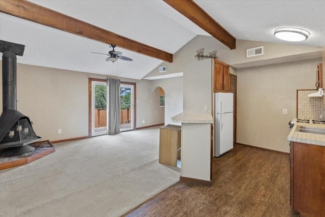 502 Grace Ln, Austin, TX 78746 - kitchen featuring freestanding refrigerator, ceiling fan, light countertops, open floor plan, and a wood stove