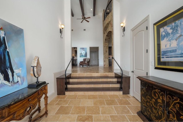 8315 Lime Creek Rd, Volente, TX 78641 - foyer entrance featuring a ceiling fan, a high ceiling, stairway, stone finish floors, and beam ceiling
