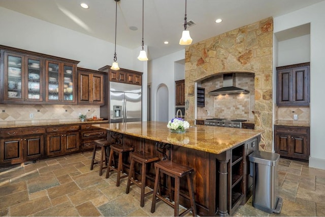 8315 Lime Creek Rd, Volente, TX 78641 - kitchen with wall chimney exhaust hood, stainless steel fridge with ice dispenser, backsplash, a center island with sink, and recessed lighting