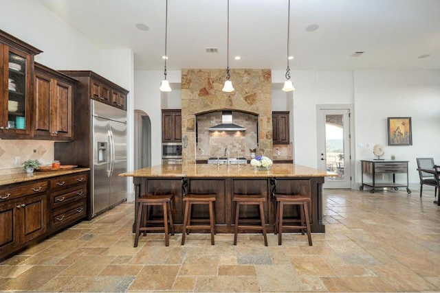 8315 Lime Creek Rd, Volente, TX 78641 - kitchen featuring appliances with stainless steel finishes, stone tile flooring, and backsplash