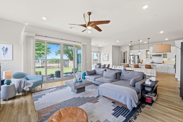 living room with recessed lighting, light wood-style floors, and ceiling fan