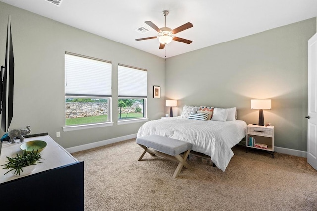 carpeted bedroom with visible vents, baseboards, and ceiling fan