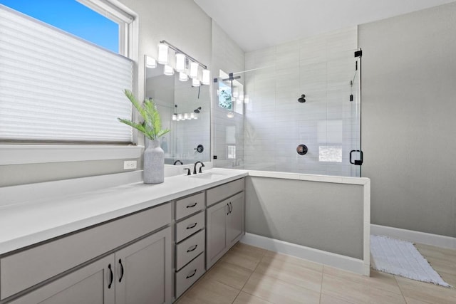 full bath with baseboards, vanity, tile patterned floors, and a stall shower
