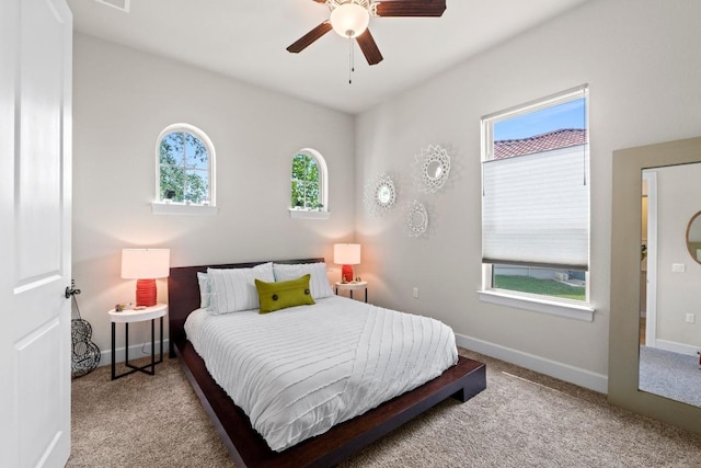carpeted bedroom featuring baseboards and ceiling fan