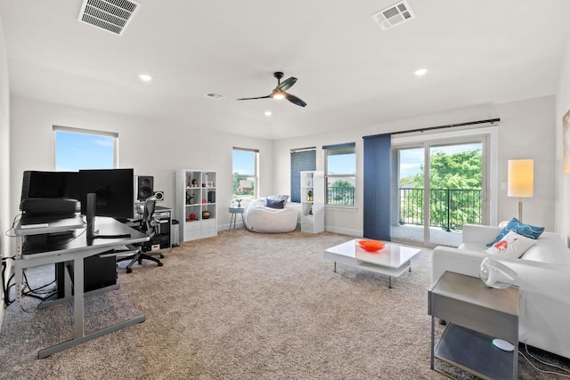 carpeted living area with plenty of natural light, a ceiling fan, and visible vents