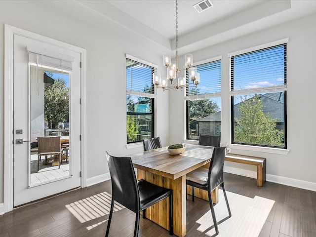 dining space featuring dark wood finished floors, an inviting chandelier, visible vents, and baseboards