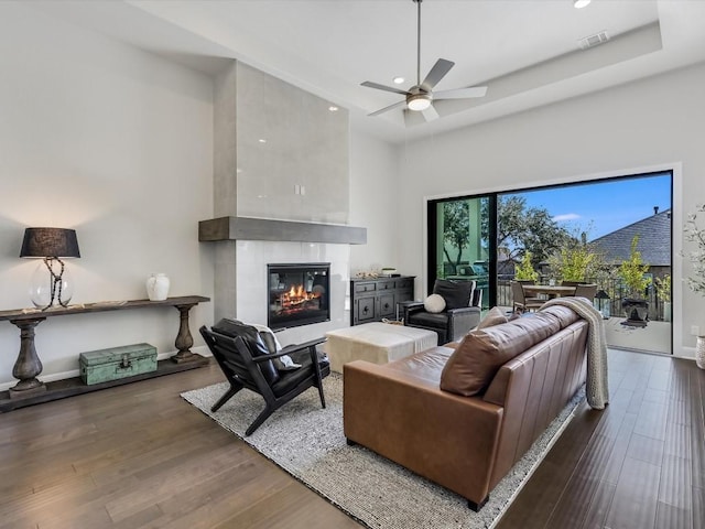 living area featuring recessed lighting, wood finished floors, a tiled fireplace, and a ceiling fan