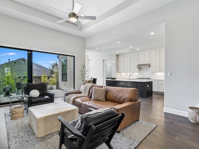 living area featuring baseboards, dark wood-style flooring, a ceiling fan, and recessed lighting