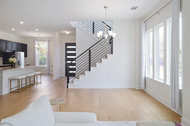 4323 Attra St, Austin, TX 78723 - living area with stairs, a chandelier, light wood-style floors, baseboards, and visible vents
