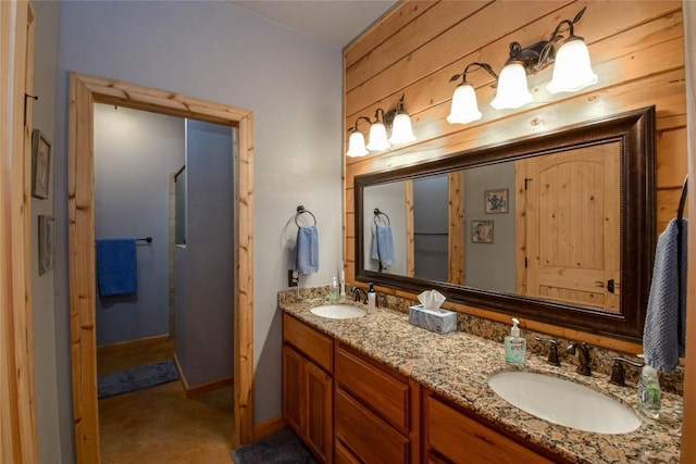 full bathroom with double vanity, baseboards, and a sink