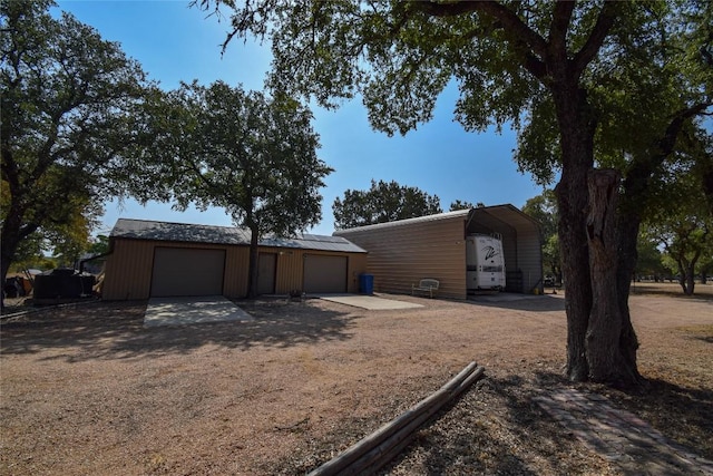 exterior space with driveway, an outbuilding, and a garage