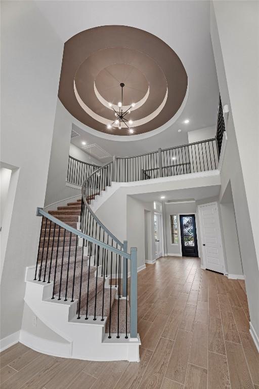 7413 Desert Needle Dr, Lago Vista, TX 78645 - entryway featuring a towering ceiling, a raised ceiling, wood finished floors, baseboards, and a chandelier